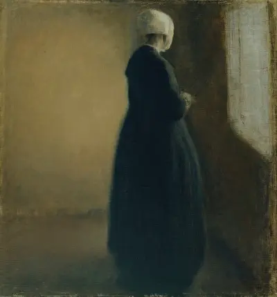 An old woman standing by a window av Vilhelm Hammershøi