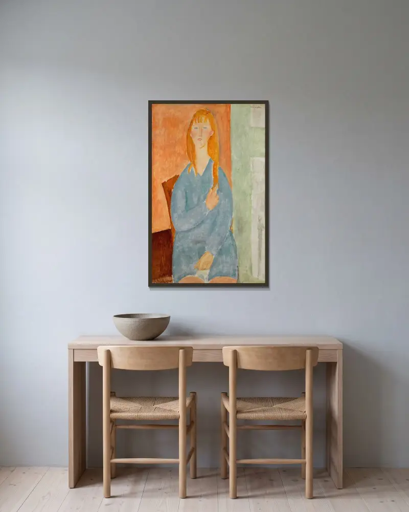 Sittande ung flicka med utsläppt hår (Flicka i blått) av Amedeo Modigliani inramad på en vägg