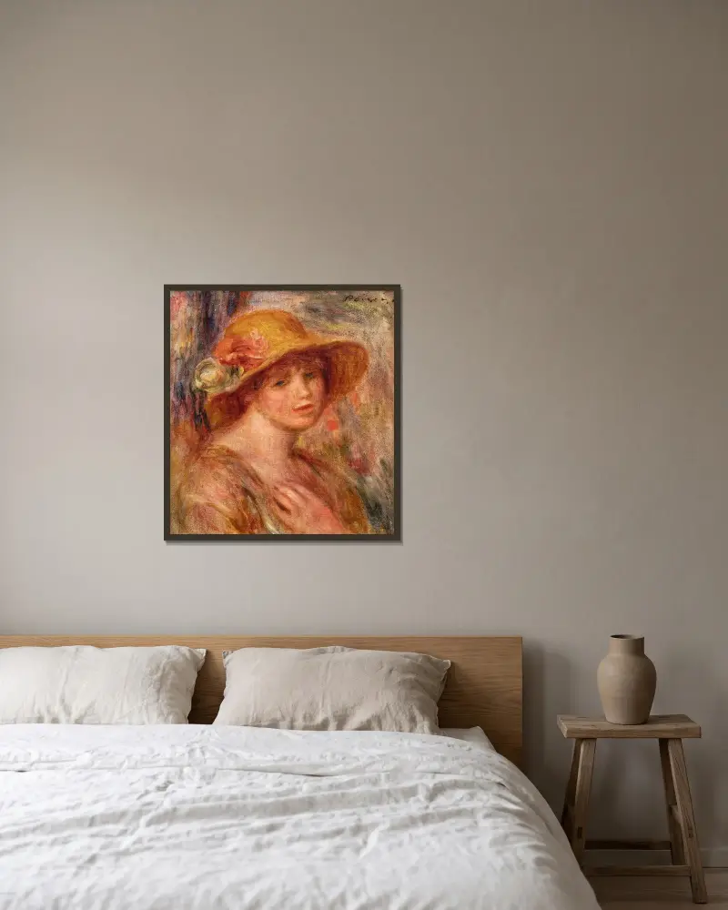 Kvinna med stråhatt av Pierre-Auguste Renoir inramad på en vägg