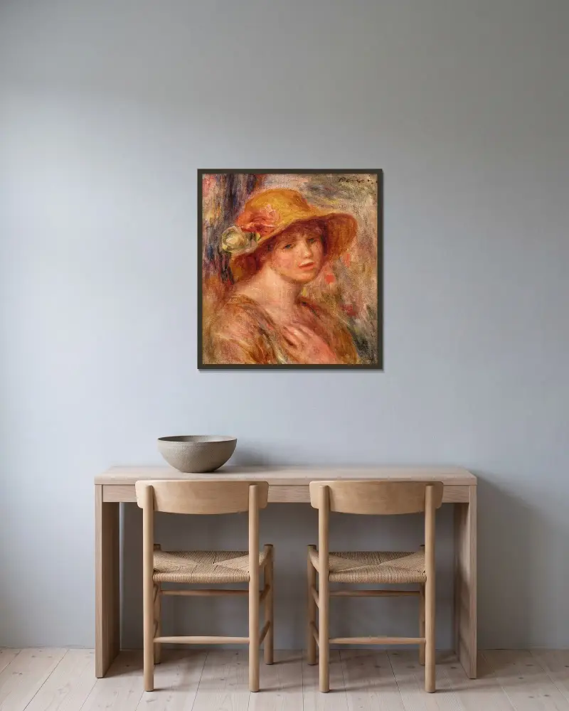 Kvinna med stråhatt av Pierre-Auguste Renoir inramad på en vägg