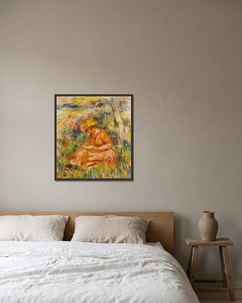 Kvinna läsande i landskap av Pierre-Auguste Renoir inramad på en vägg