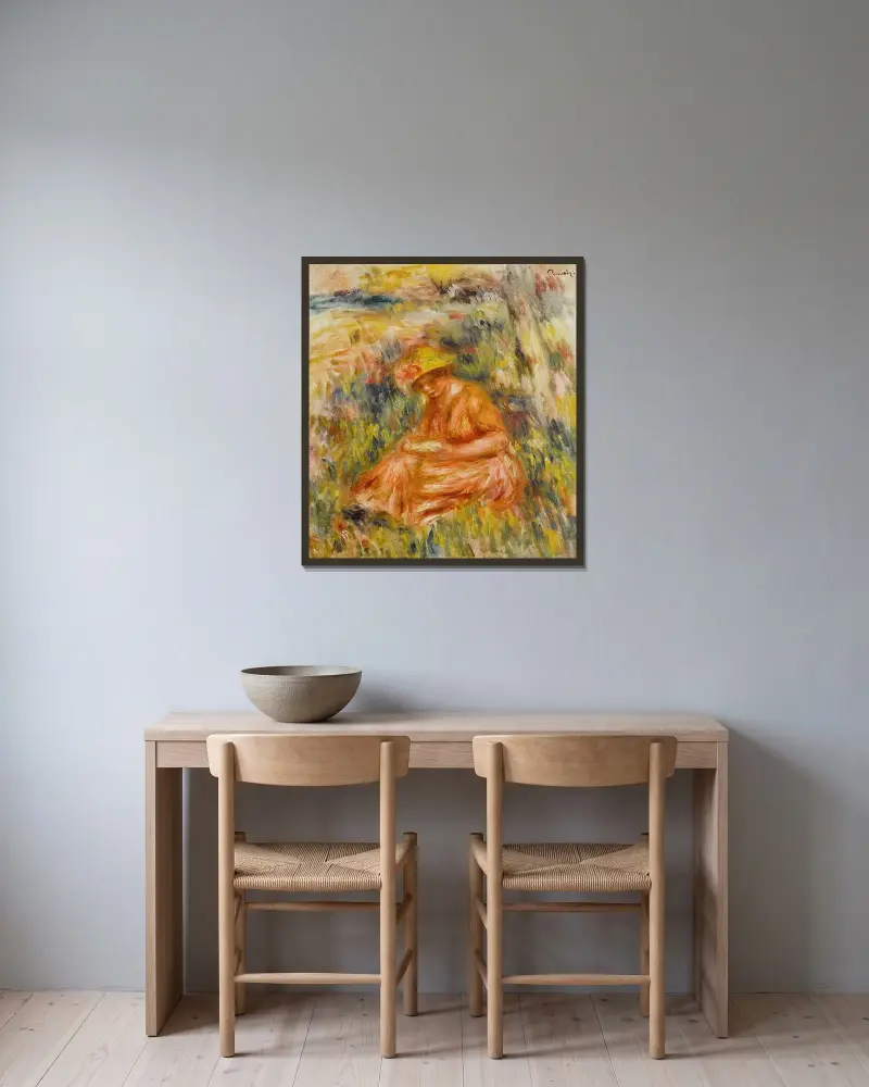 Kvinna läsande i landskap av Pierre-Auguste Renoir inramad på en vägg