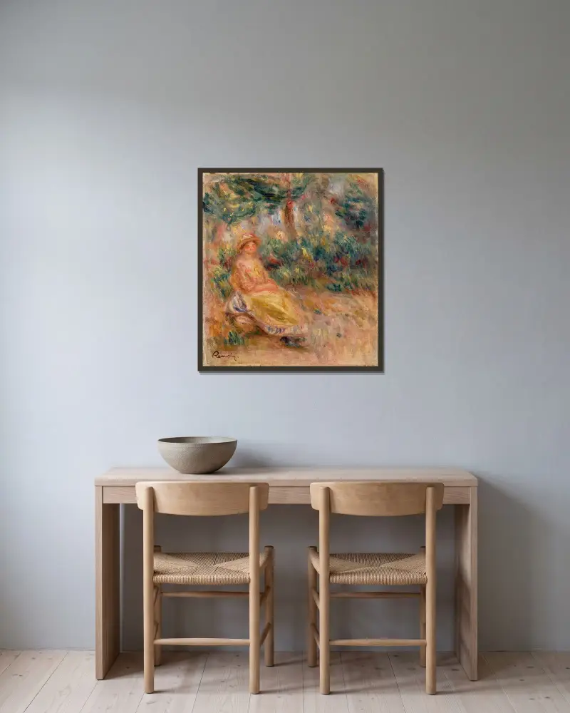 Kvinna i rosa och gult i ett landskap av Pierre-Auguste Renoir inramad på en vägg