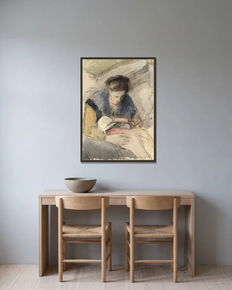 Ung kvinna som syr av Camille Pissarro inramad på en vägg