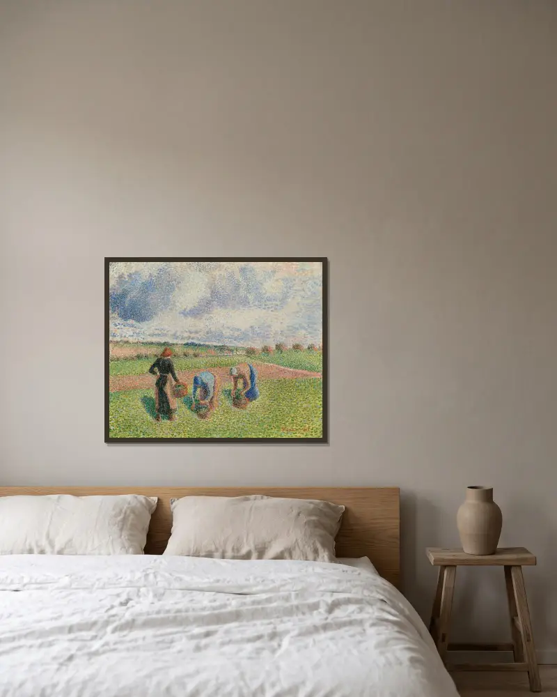 Kvinnor som samlar gräs, Éragny av Camille Pissarro inramad på en vägg