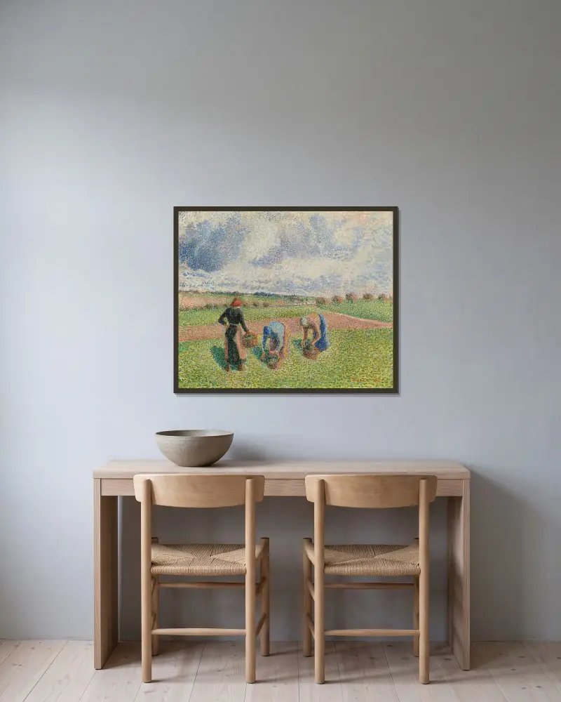 Kvinnor som samlar gräs, Éragny av Camille Pissarro inramad på en vägg