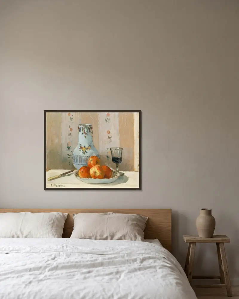 Stilleben med äpplen och kanna av Camille Pissarro inramad på en vägg