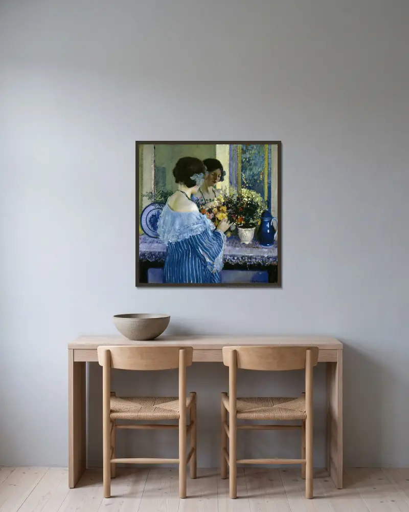 Flicka i blått ordnar blommor av Frederick Carl Frieseke inramad på en vägg