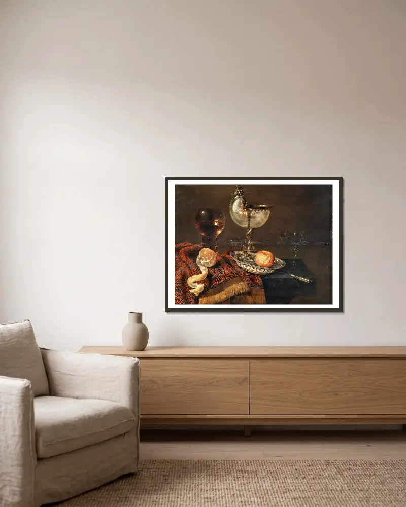 En klementin i en porslinsskål, en nautiluspokal, ett roemer, två glas, en kniv, en skalad citron på en prydnadsmatta på ett bord av Willem Claesz Heda inramad på en vägg