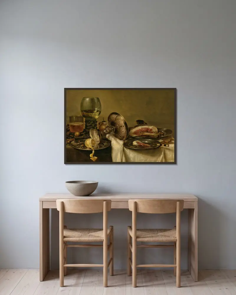 A partially draped table with an overturned tazza, roemer and glass of beer, with a partially peeled lemon and ham on pewter plates av Willem Claesz Heda inramad på en vägg