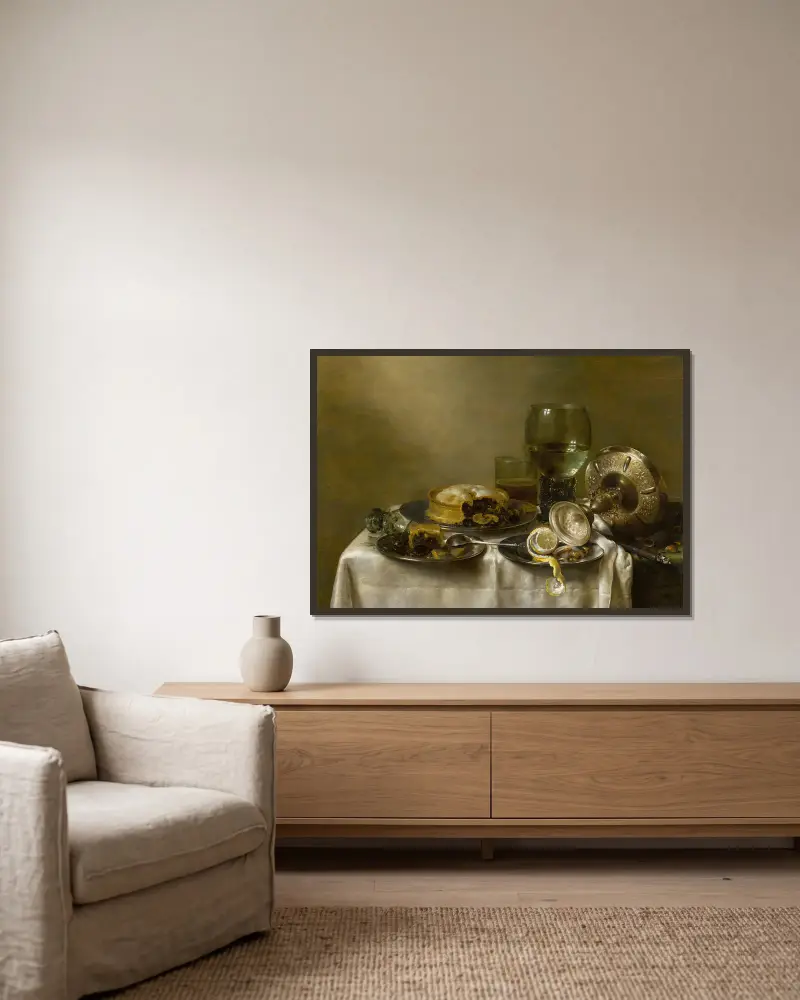 Stilleben med en omkullvält silverbägare, glas, pajer och en skalad citron på ett bord av Willem Claesz Heda inramad på en vägg