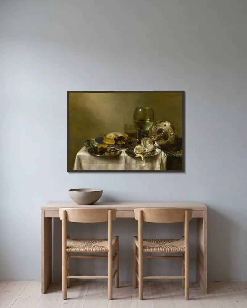 Stilleben med en omkullvält silverbägare, glas, pajer och en skalad citron på ett bord av Willem Claesz Heda inramad på en vägg