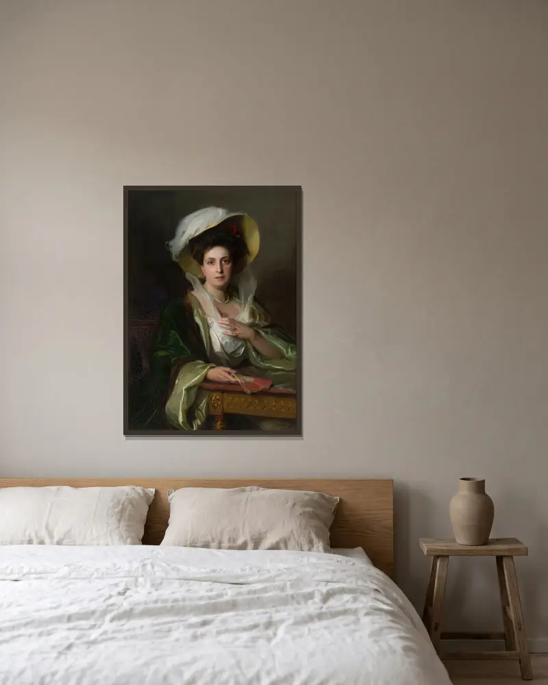 Porträtt av en dam i stor hatt av Philip Alexius de László inramad på en vägg