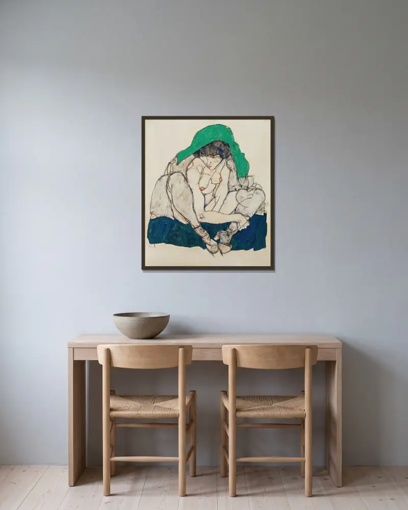 Hukande kvinna med grön huvudduk av Egon Schiele inramad på en vägg