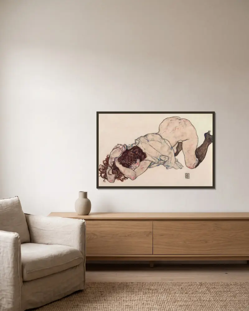 Knästående flicka, vilande på båda armbågarna av Egon Schiele inramad på en vägg