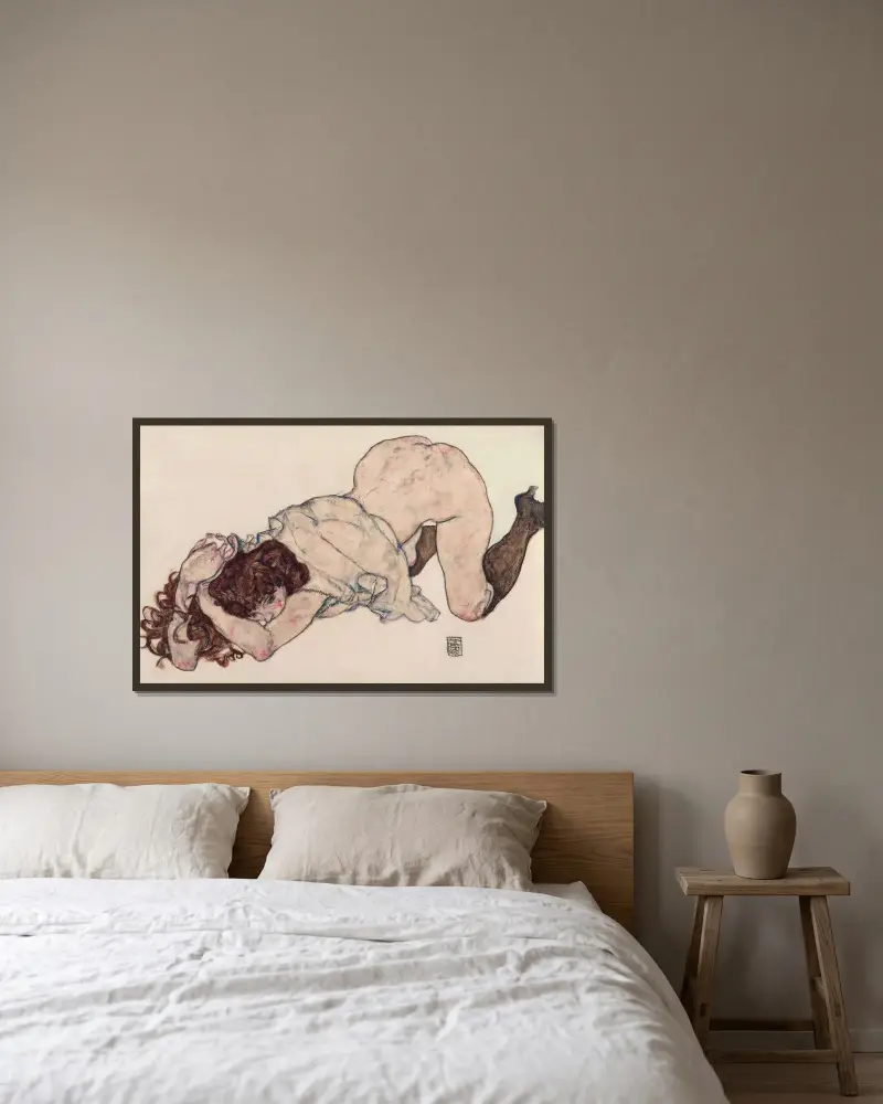 Knästående flicka, vilande på båda armbågarna av Egon Schiele inramad på en vägg