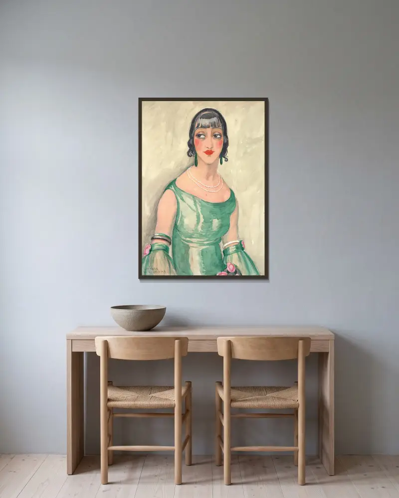 Porträtt av kvinna i grön klänning och pärlor av Gerda Wegener inramad på en vägg
