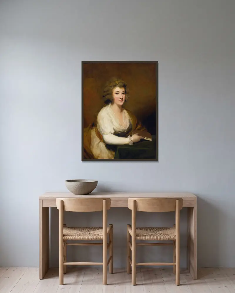 Porträtt av Lady Nasmyth, i vit klänning och brun sjal, sittande vid ett bord med en bok av Sir Henry Raeburn inramad på en vägg