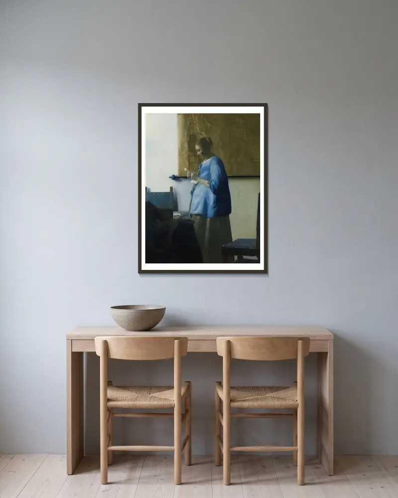 Woman Reading a Letter av Johannes Vermeer inramad på en vägg