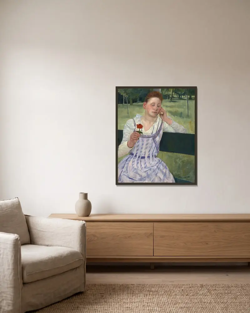 Kvinna med en röd zinnia av Mary Cassatt inramad på en vägg