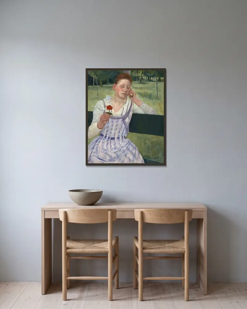 Kvinna med en röd zinnia av Mary Cassatt inramad på en vägg