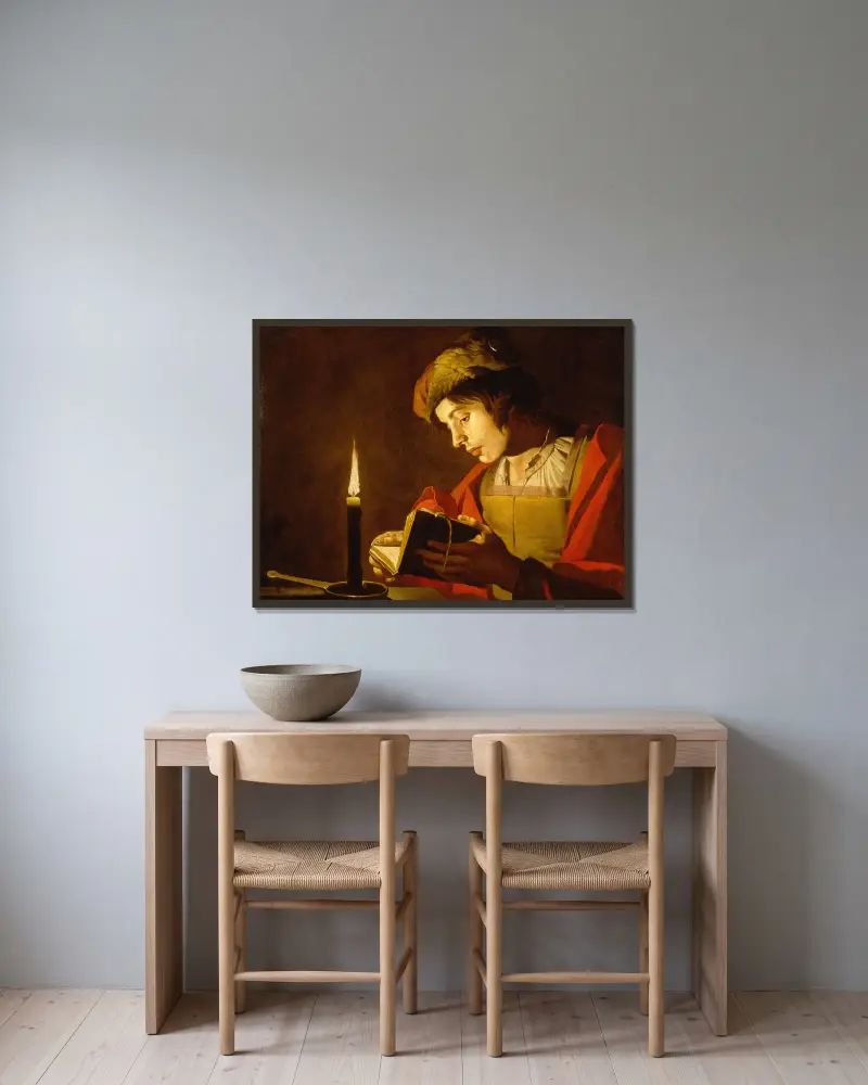 Junger Mann beim Lesen bei Kerzenlicht von Matthias Stom gerahmt an einer Wand