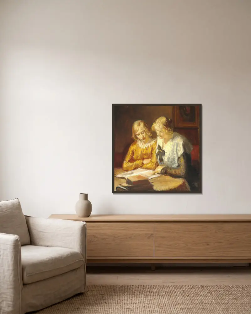 Två unga flickor sitter vid bordet och läser i en bok av Michael Ancher inramad på en vägg