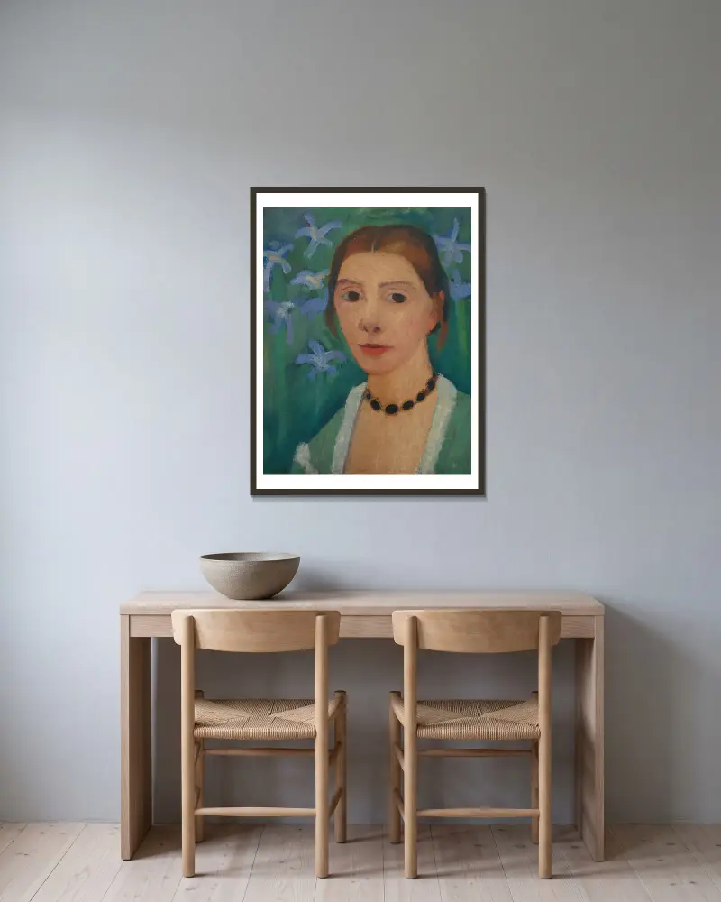 Selbstbildnis vor grünem Hintergrund mit blauer Iris von Paula Modersohn-Becker gerahmt an einer Wand