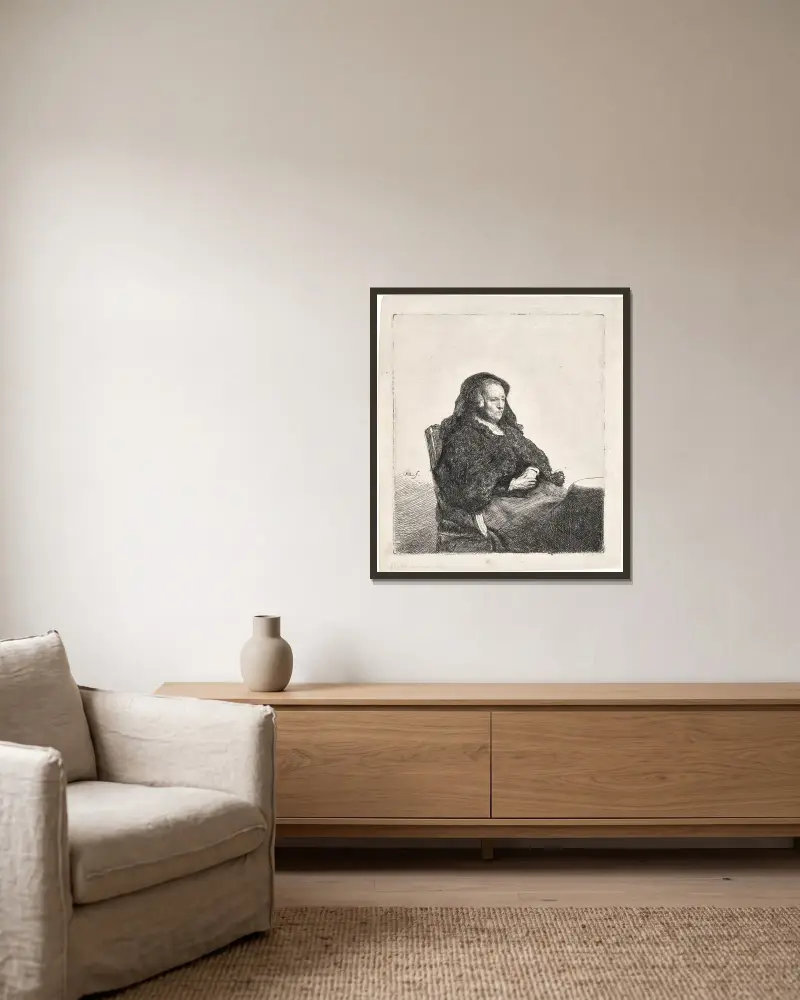 Die Mutter des Künstlers an einem Tisch sitzend, nach rechts blickend von Rembrandt van Rijn gerahmt an einer Wand