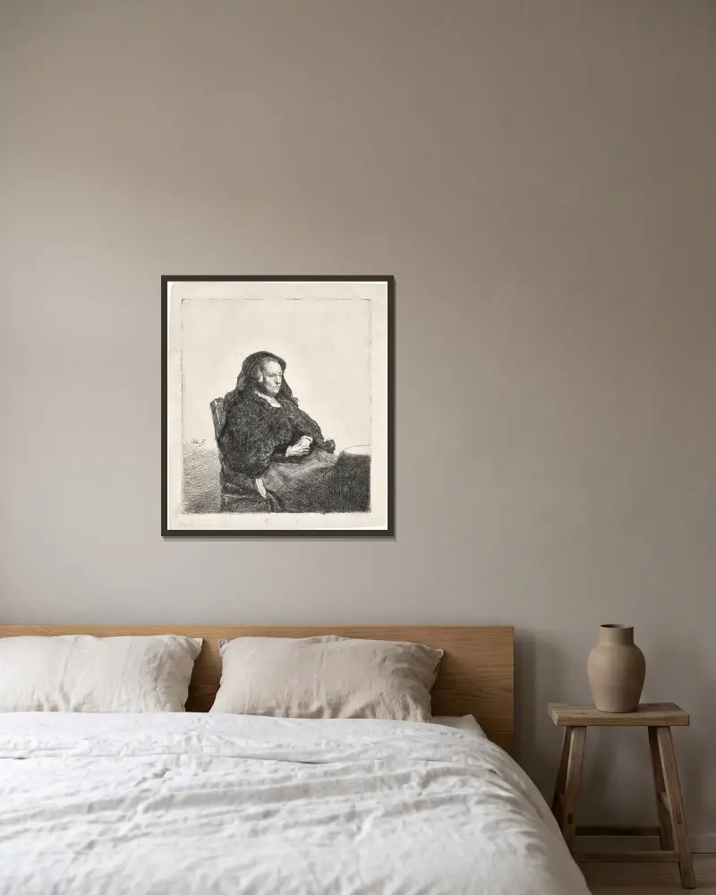 Die Mutter des Künstlers an einem Tisch sitzend, nach rechts blickend von Rembrandt van Rijn gerahmt an einer Wand