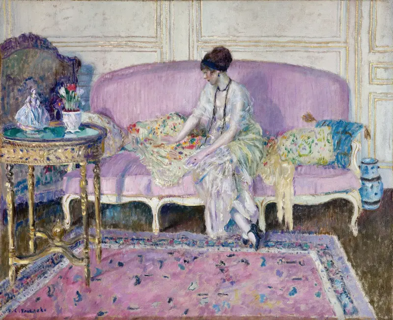 Kvinna sittande på soffa i interiör av Frederick Carl Frieseke