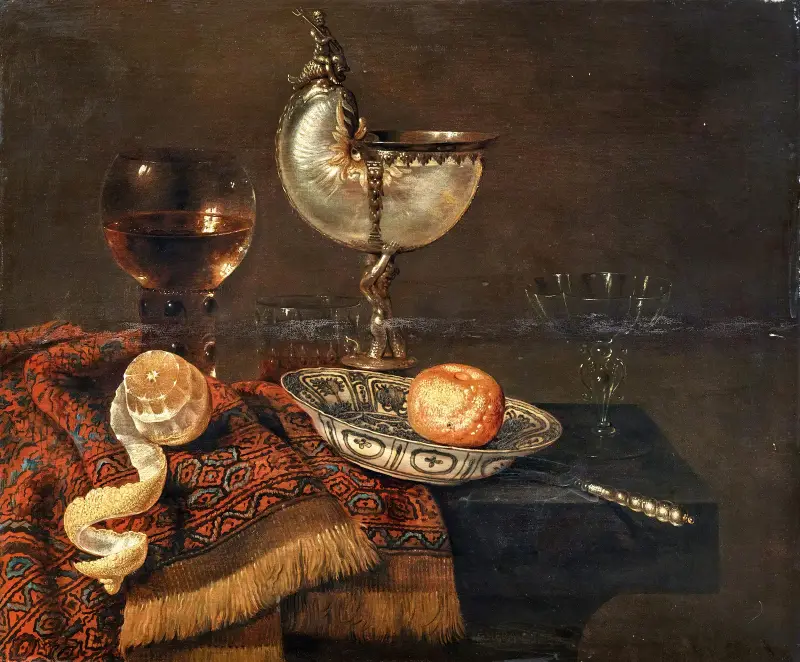 En klementin i en porslinsskål, en nautiluspokal, ett roemer, två glas, en kniv, en skalad citron på en prydnadsmatta på ett bord av Willem Claesz Heda