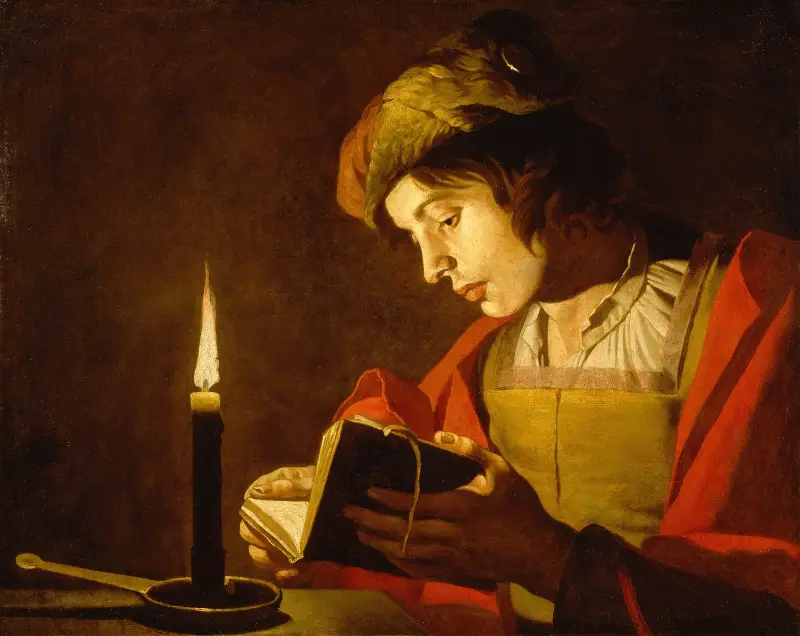 Junger Mann beim Lesen bei Kerzenlicht von Matthias Stom